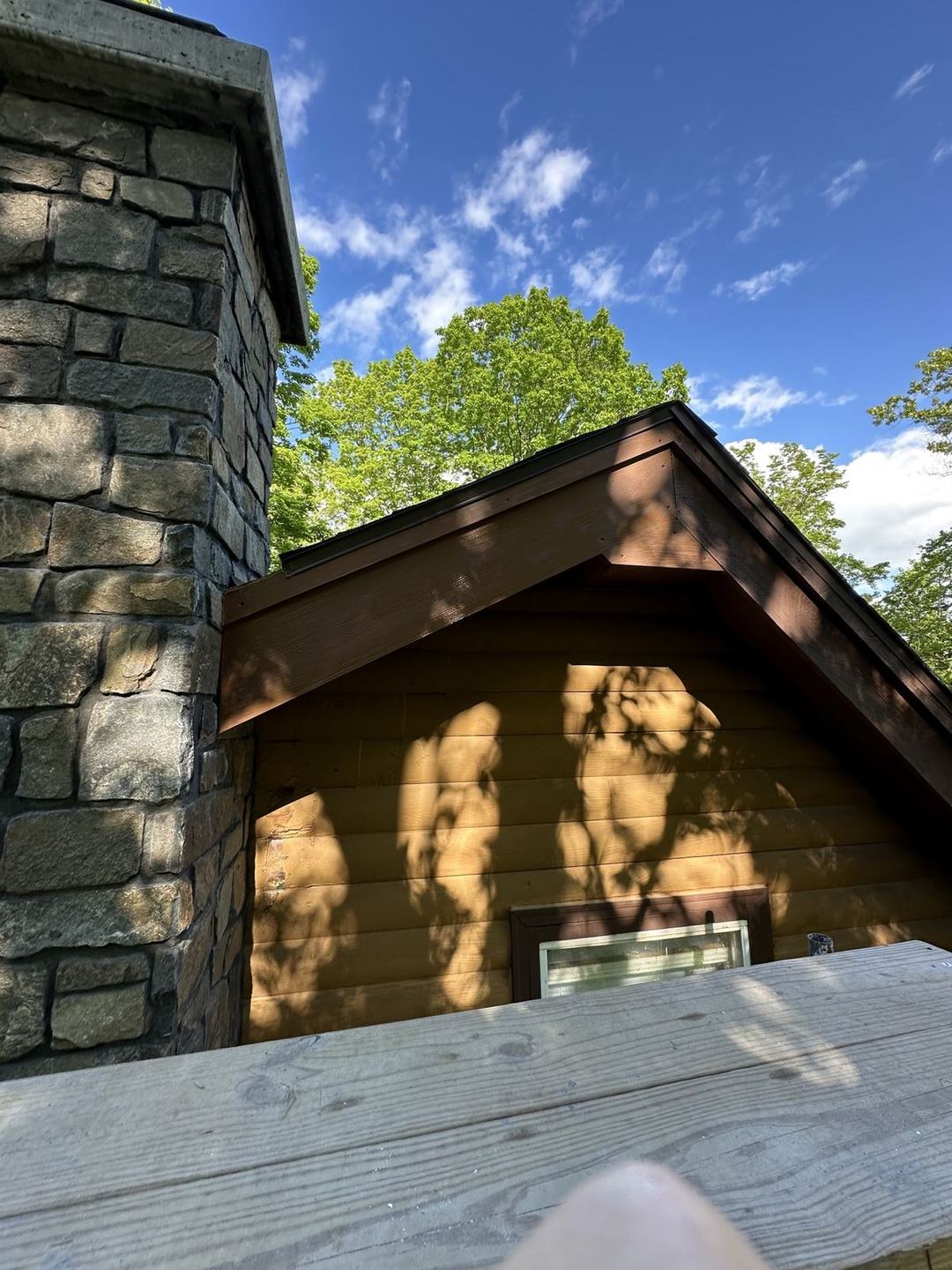 Finished stone chimney in bright sunlight with tight mortar joints