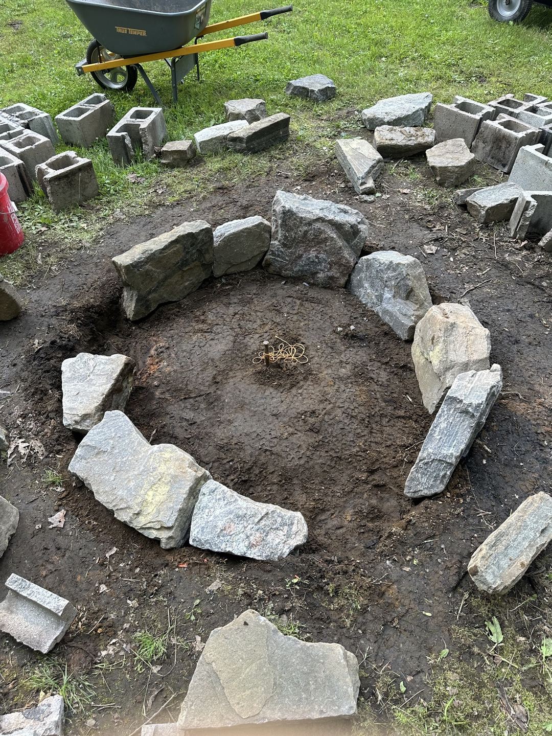 First ring of boulders laid around a center stake for the fire pit