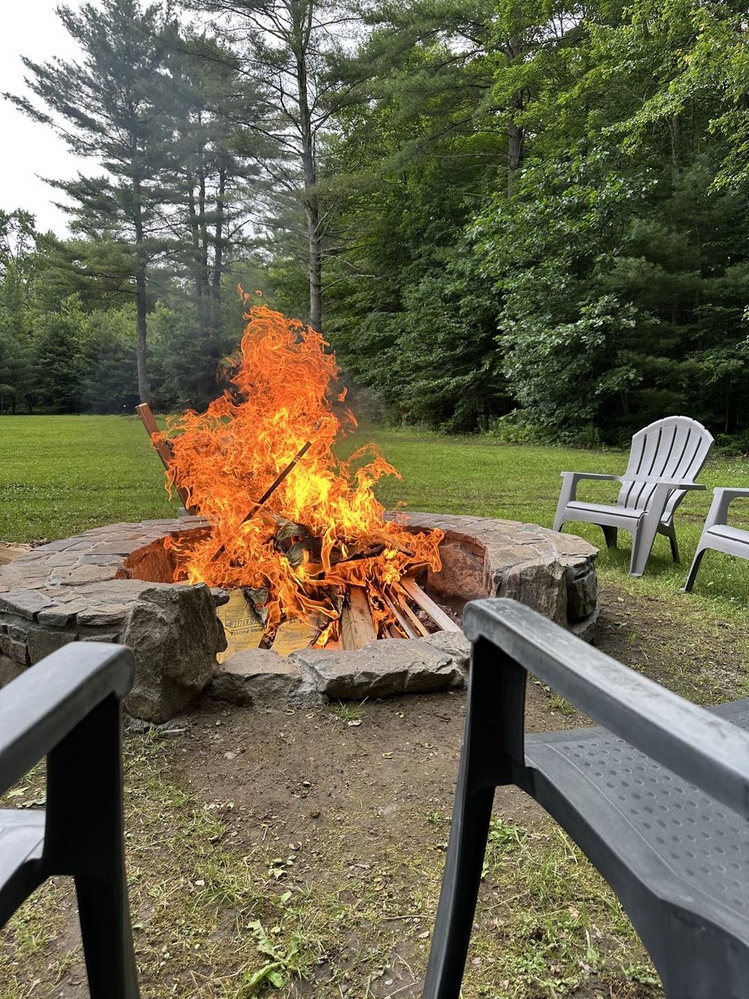 Finished stone fire pit with a fire burning in it